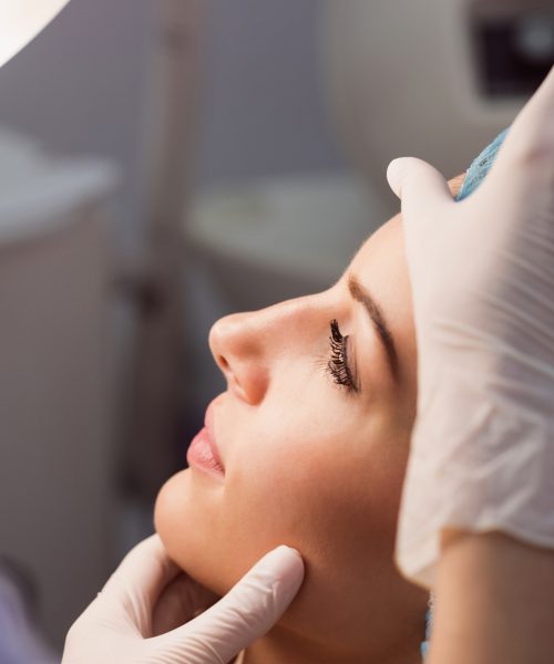 doctor-examining-womans-face-cosmetic-treatment